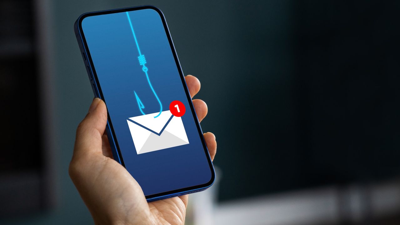 A smartphone screen is lit up with an email icon connected to a fish hook.