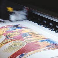 Professional printing machine printing a colorful document.