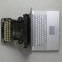 Top View of a vintage typewriter back to back with a modern laptop computer
