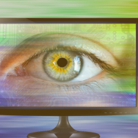 Eye looking through a computer screen to signify spyware