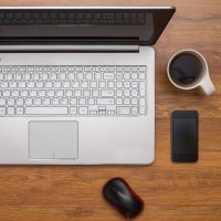 Laptop computer,  a computer mouse and a cup of coffee