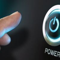 Finger moving toward a power button with power symbol