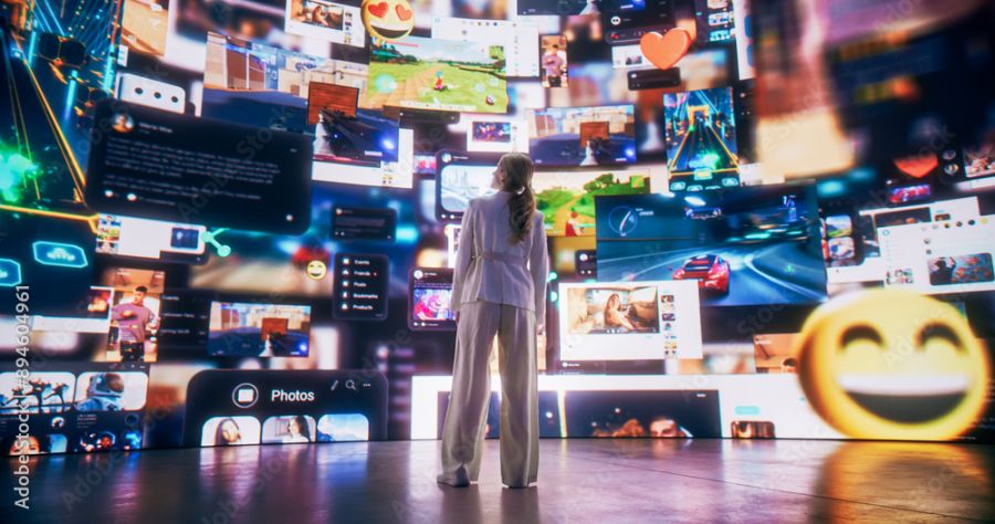 Person standing in front of computer windows of various apps