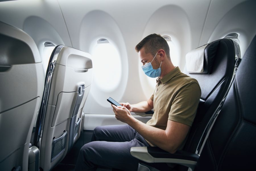Man on plane checking his smartphone