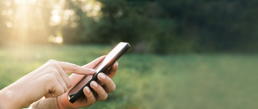 Person's hands tapping the touchscreen on a smartphone.