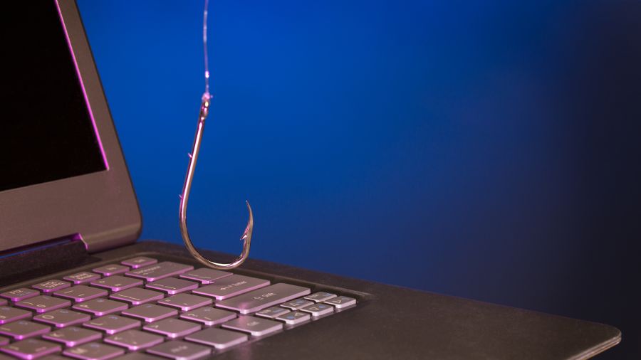 A picture of a fishing hook dangling over a laptop