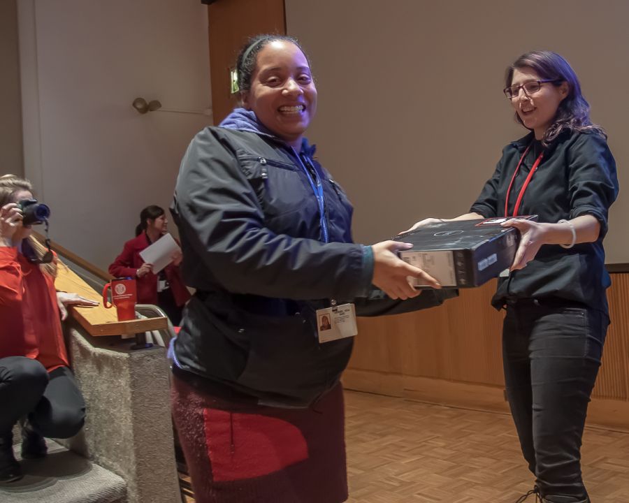 WCM staff member giving another wcm staff member a laptop as a raffle gift