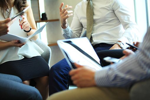 A group of people sitting in a meeting.