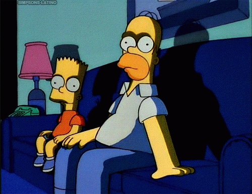 GIF of Homer and Bart Simpson sitting on a couch in the dark. Homer ominously pats the couch for you to join them.