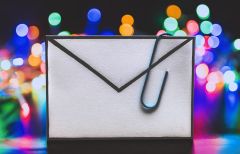 An email letter icon with a paperclip attached to it.