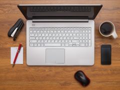 Laptop computer,  a computer mouse and a cup of coffee