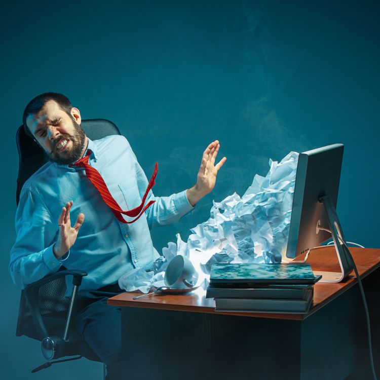 Man being bombarded with mail spilling out of his computer screen.