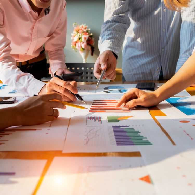 Colleagues looking at various printouts of metrics on a conference table.