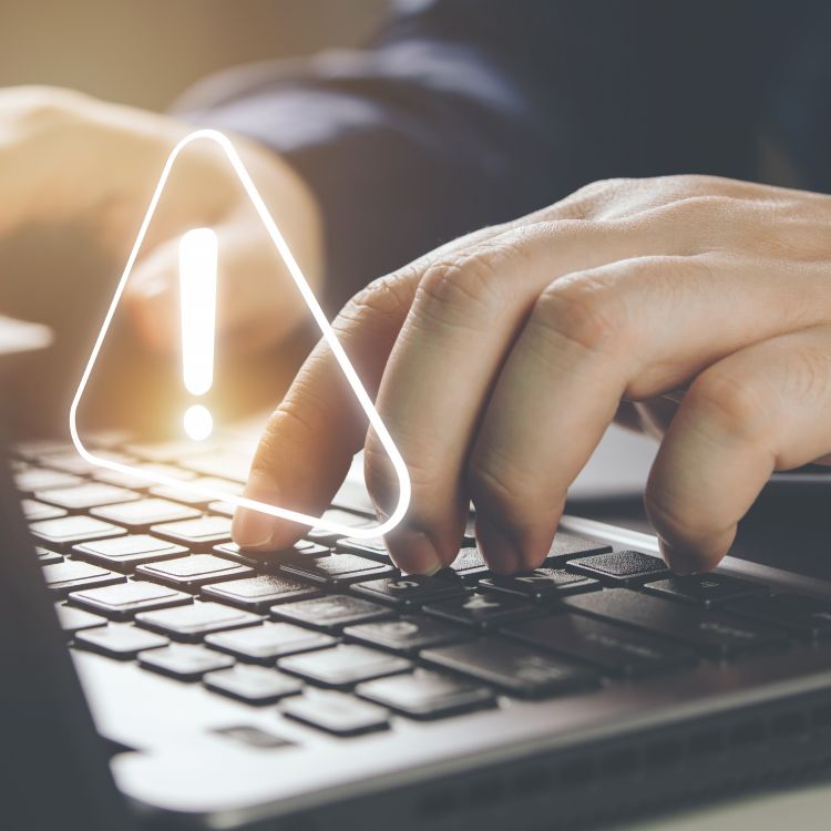 Laptop with alert symbol superimposed