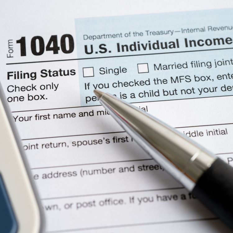 1040 tax form with a pen and calculator on top of it